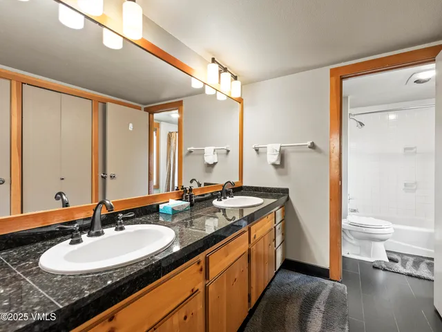 a bathroom with a granite countertop sink double vanity and a mirror