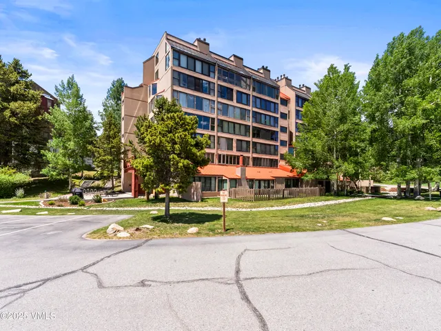 a front view of building with yard and trees