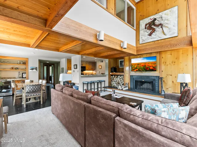 a living room with furniture a fireplace and kitchen view