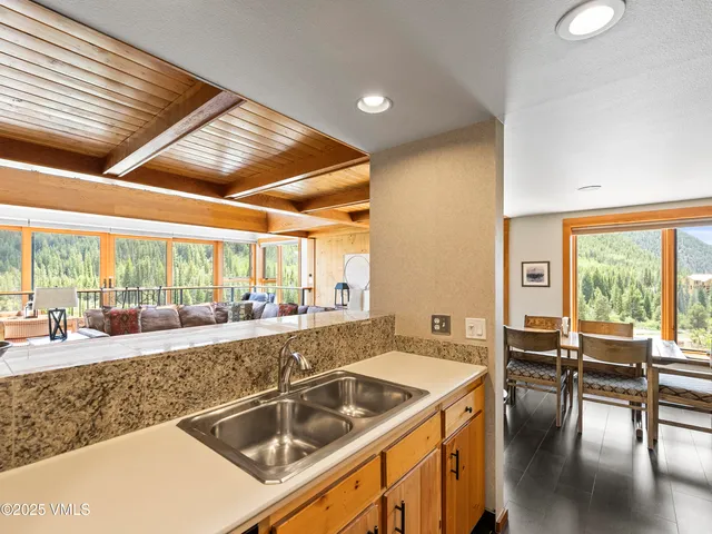 a kitchen with a stove a sink and white cabinets with wooden floor