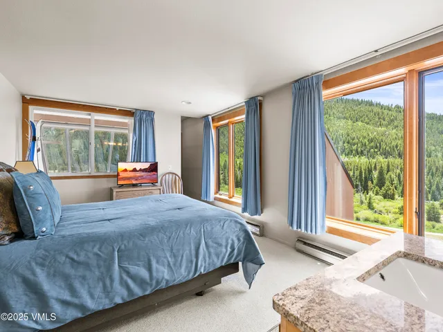 a bedroom with a bed and glass windows