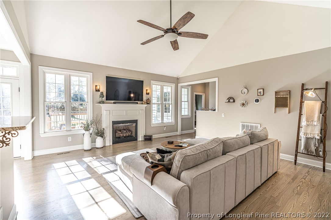 1163 Rays Bridge Road Whispering Pines, NC 28327 - Photo 5 of 37 a living room with furniture a fireplace and a flat screen tv
