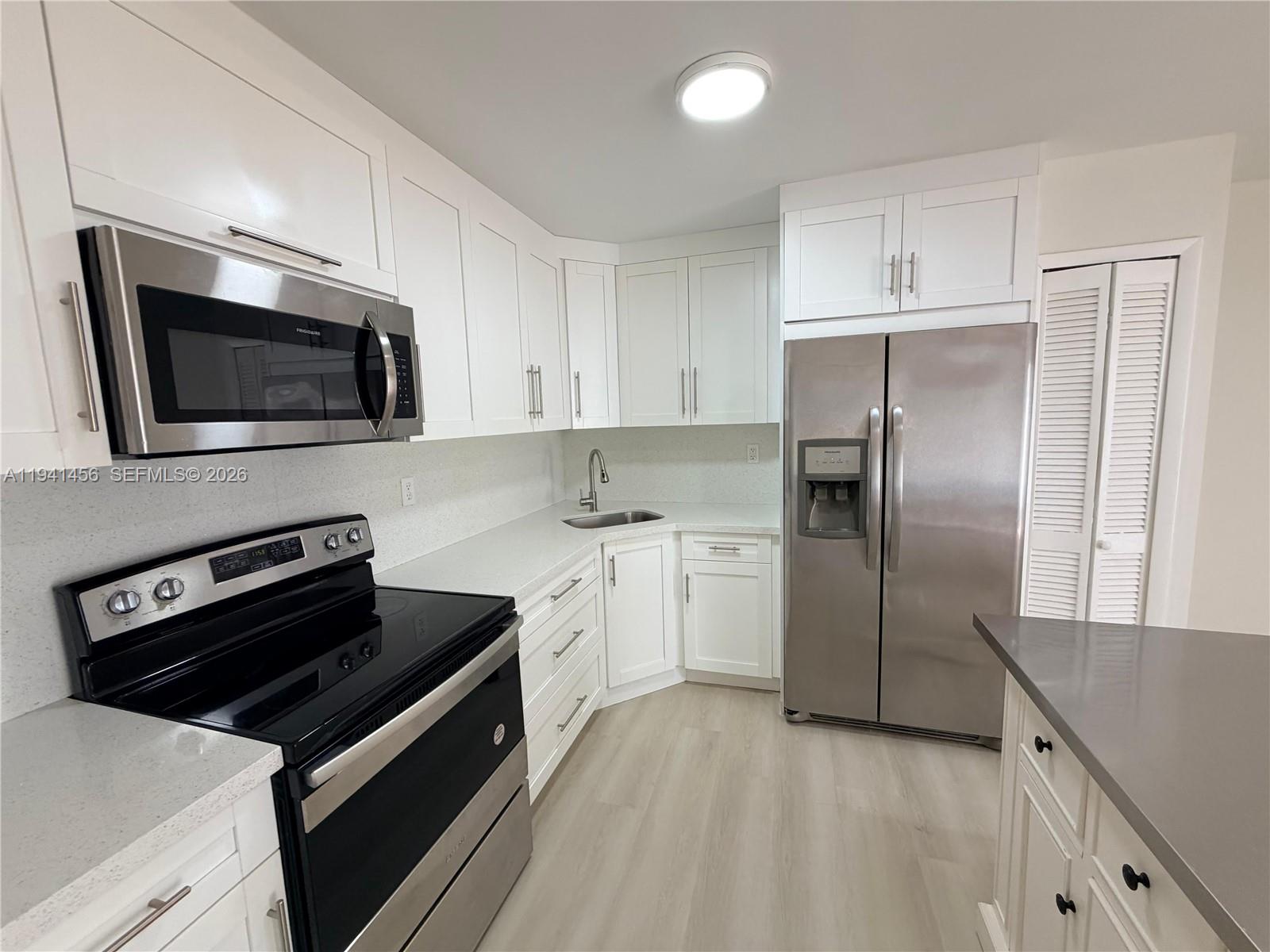6514 Southwest 128th Place, Unit 6514 Miami, FL 33183 - Photo 9 of 18 a kitchen with a refrigerator stove and microwave