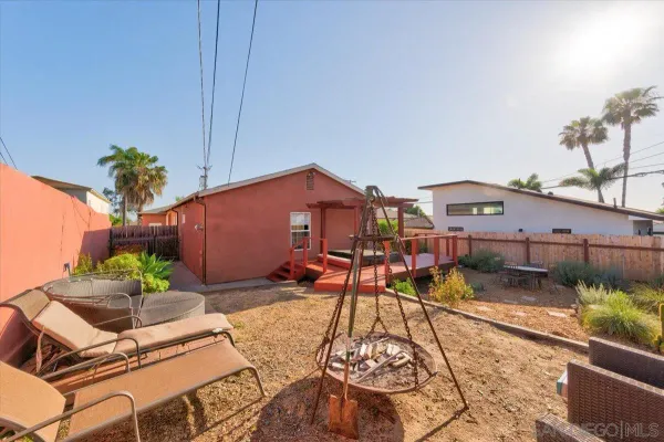 a view of a backyard with furniture and a fire pit