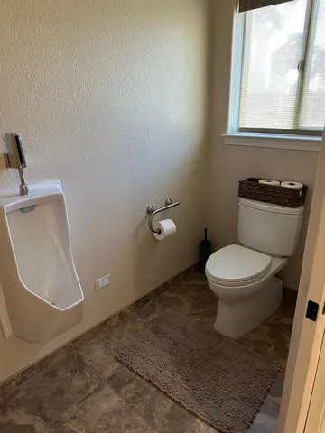 a white toilet sitting next to a window