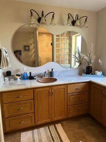 a bathroom with a granite countertop sink and a mirror