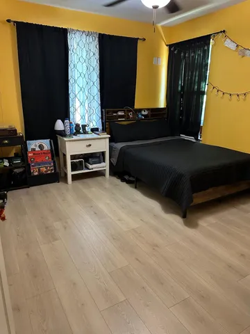 a living room with a bed furniture and a flat screen tv