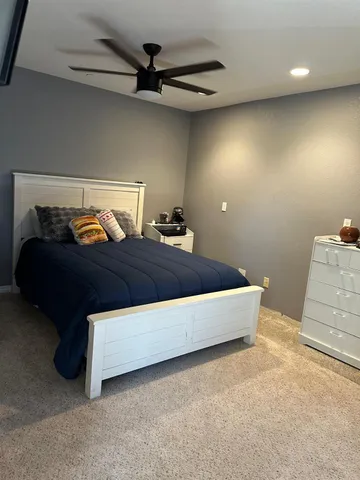a living room with a bed and a dresser