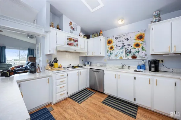 a kitchen with cabinets appliances and wooden floor