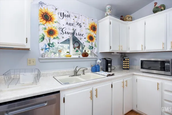 a kitchen with stainless steel appliances a sink a stove and cabinets
