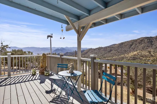 a view of a balcony with wooden floor and outdoor seating