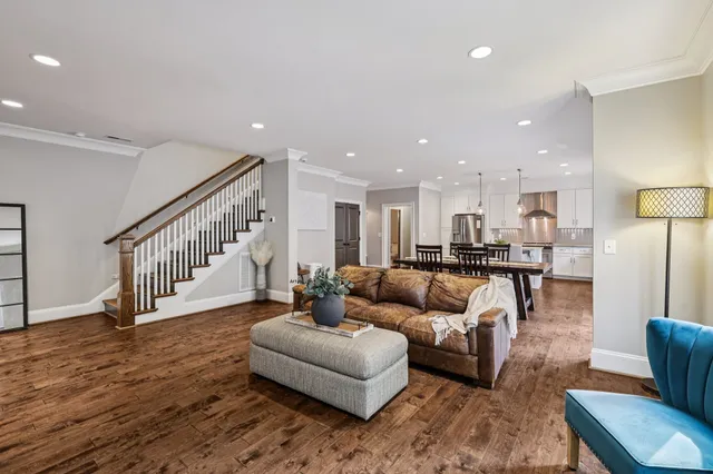 a living room with furniture and kitchen view with wooden floor
