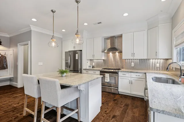 a kitchen with granite countertop cabinets stainless steel appliances and a dining table
