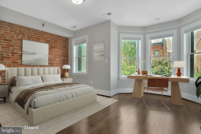 a spacious bedroom with a large bed and a large window