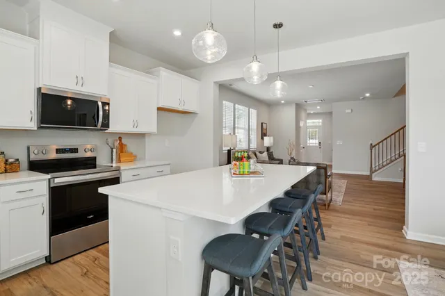 a kitchen with a dining table chairs microwave and cabinets