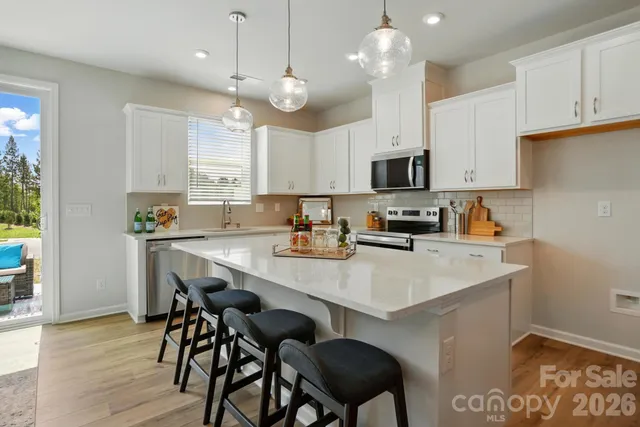 a kitchen with a dining table chairs sink and cabinets