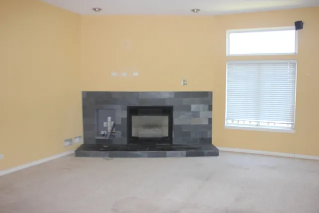 an empty room with a fireplace and a window