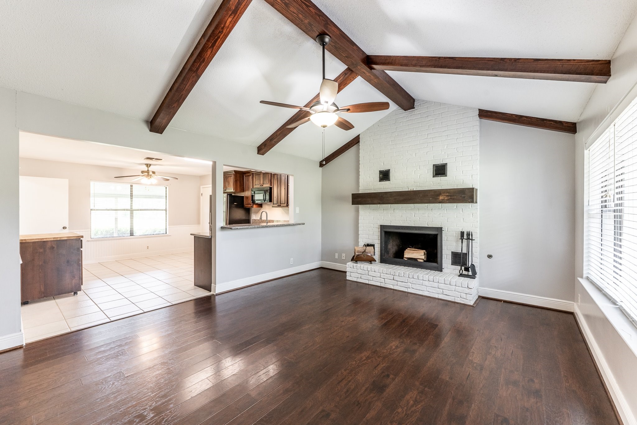 a view of a livingroom with wooden floor a fireplace and window