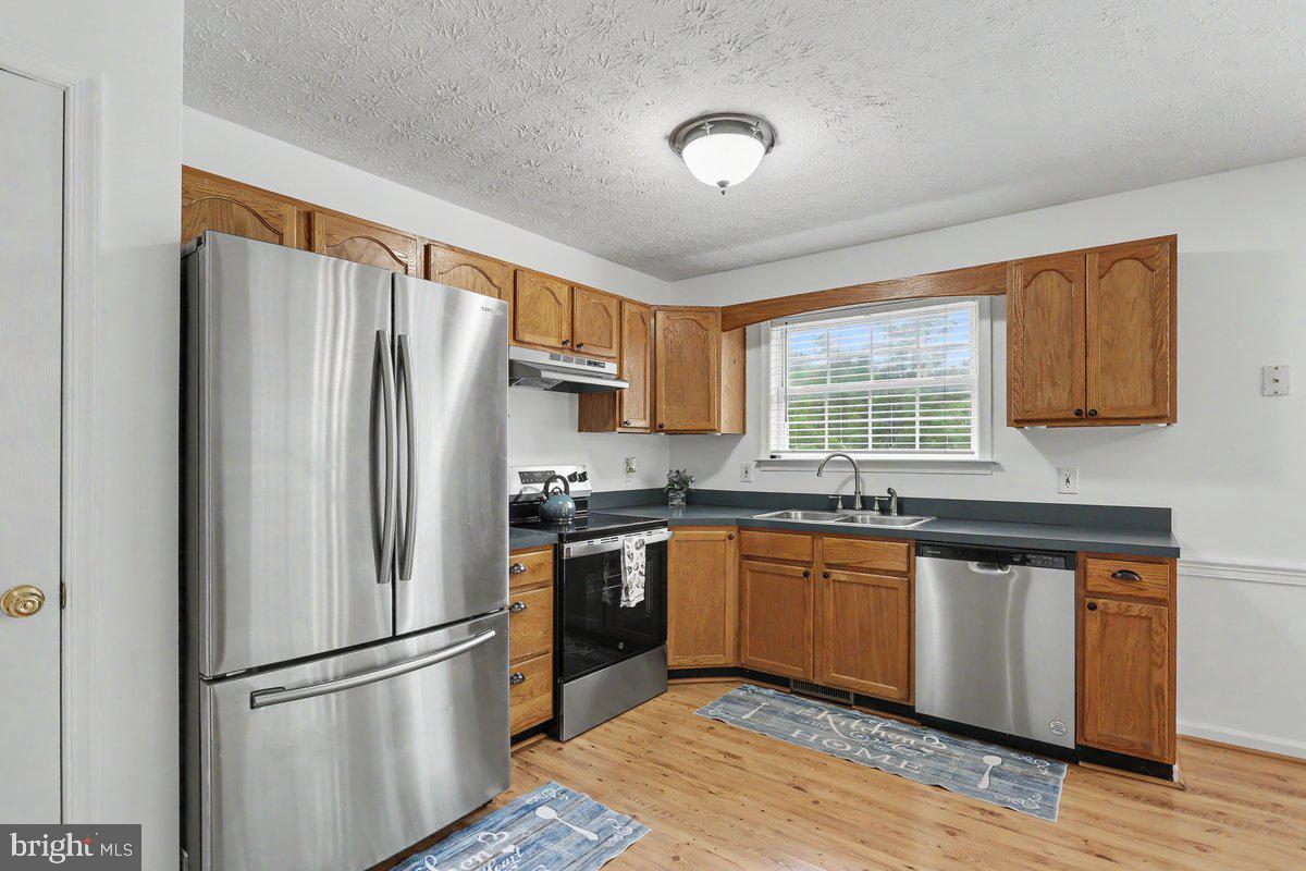 543 Whiskey Still Road Linden, VA 22642 - Photo 11 of 23 a kitchen with granite countertop stainless steel appliances a refrigerator cabinets and wooden floor