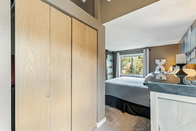 a bedroom with a bed and large windows