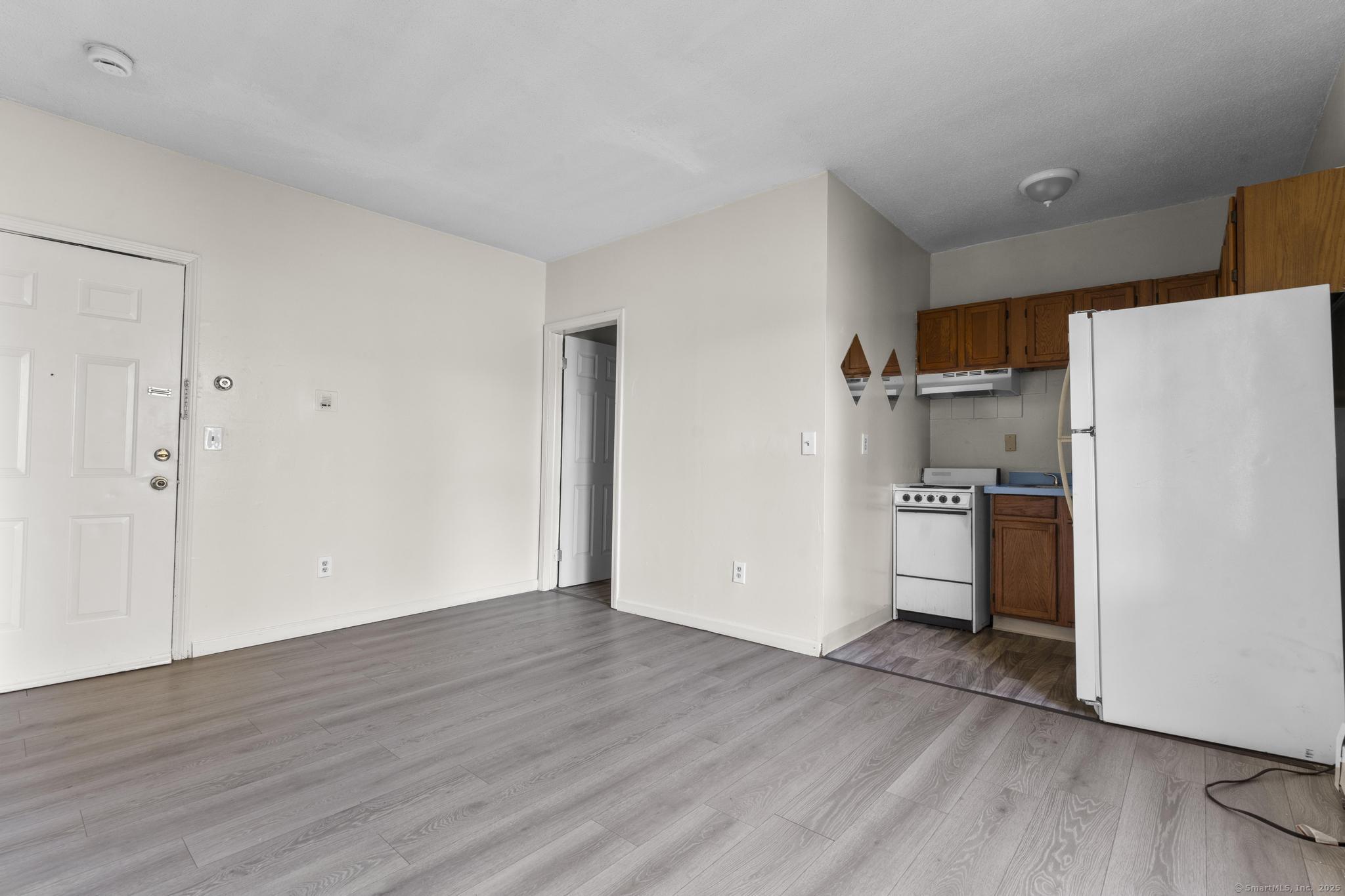 a view of a kitchen with wooden floor and electronic appliances