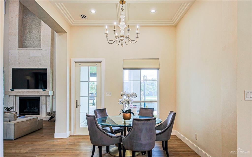 4835 Bryan Road Palmhurst, TX 78573 - Photo 27 of 45 a view of a dining room with furniture wooden floor and chandelier