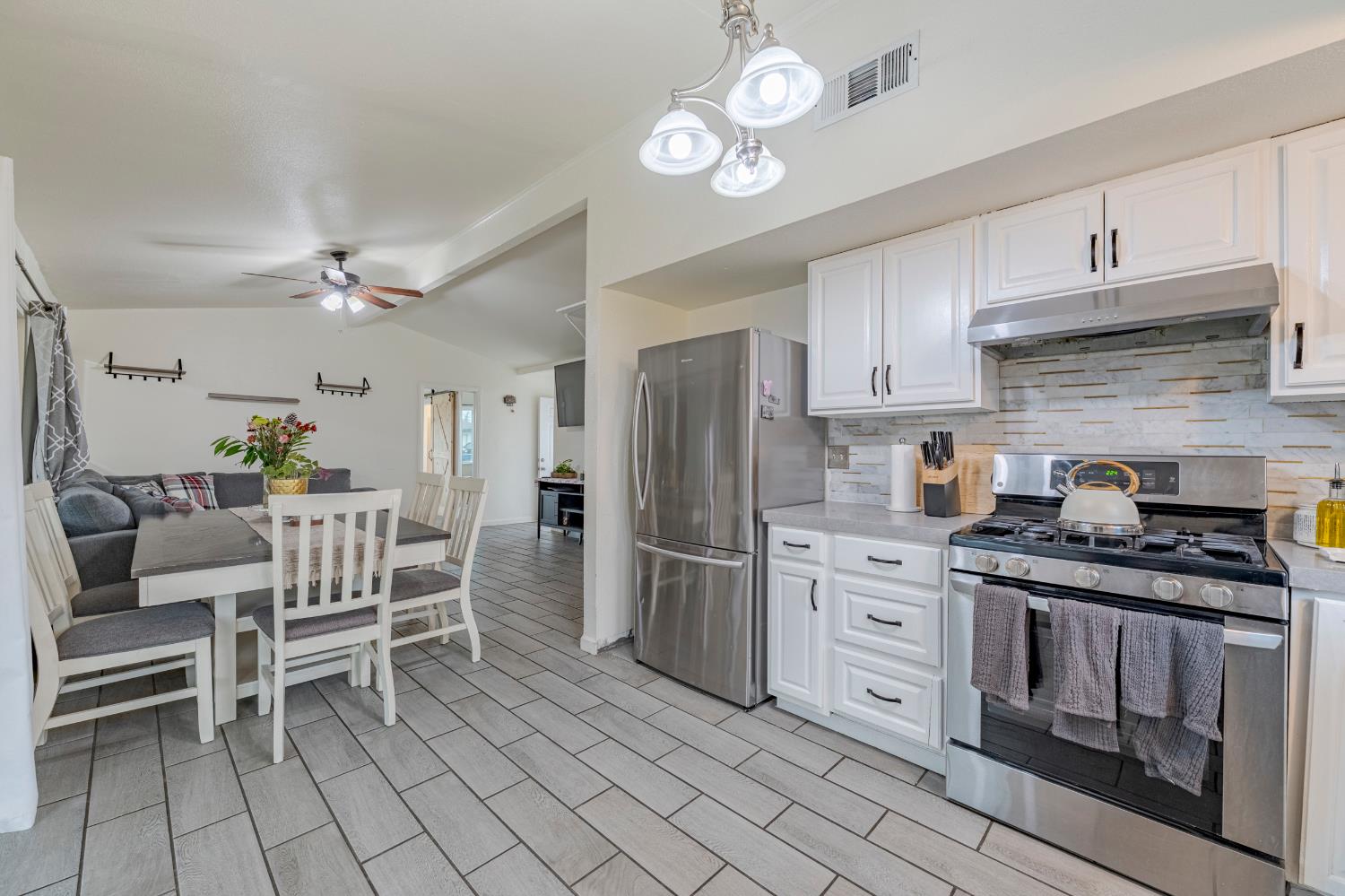 1595 East 26th Street Merced, CA 95340 - Photo 15 of 34 a kitchen with white cabinets and stainless steel appliances