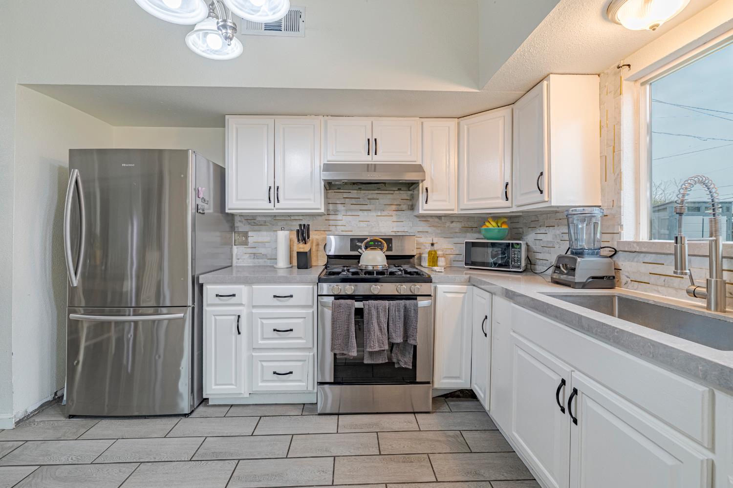 1595 East 26th Street Merced, CA 95340 - Photo 16 of 34 a kitchen with cabinets stainless steel appliances and a window