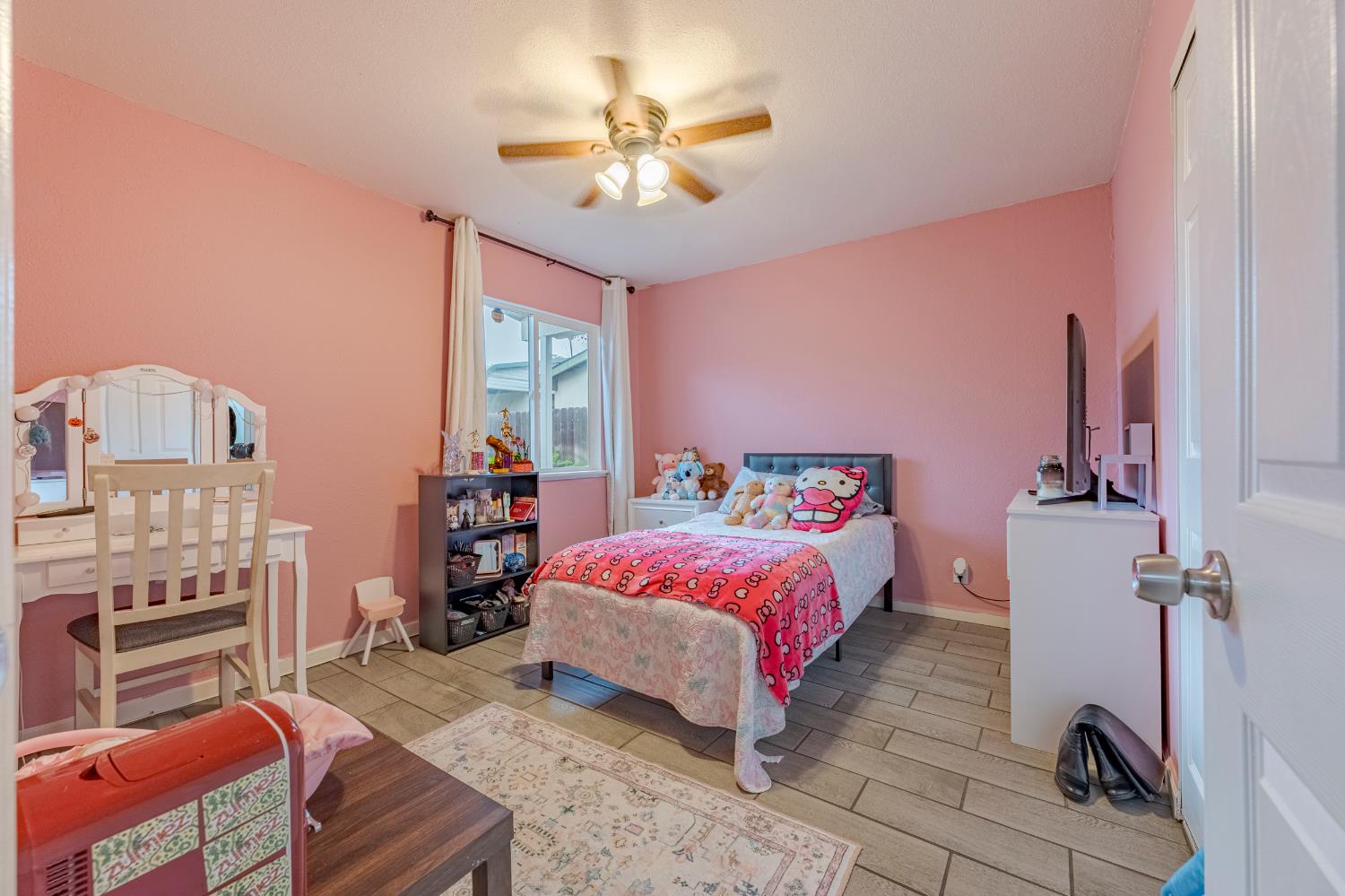 1595 East 26th Street Merced, CA 95340 - Photo 17 of 34 a bedroom with a bed and a chandelier