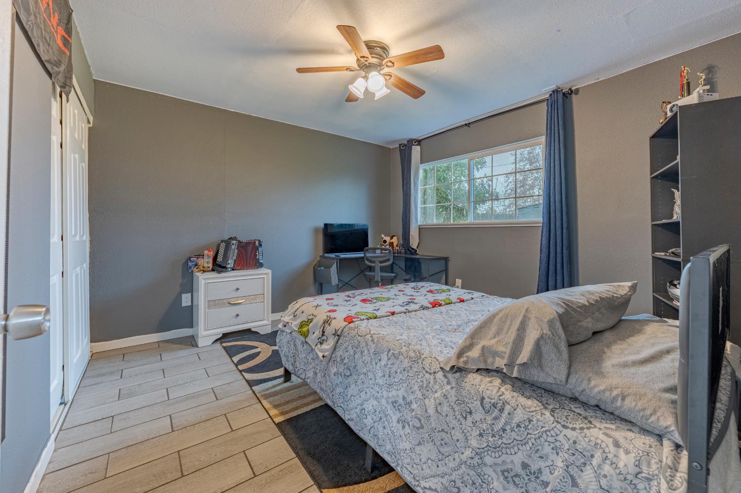 1595 East 26th Street Merced, CA 95340 - Photo 19 of 34 a bedroom with a bed and a chandelier