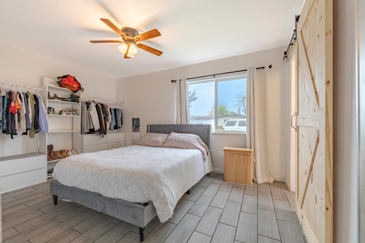 1595 East 26th Street Merced, CA 95340 - Photo 22 of 34 a bedroom with a large bed and a chandelier