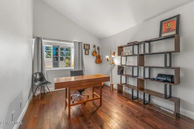a view of a workspace with furniture and wooden floor