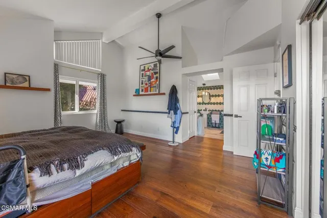 a bedroom with a bed dresser and a wooden floor