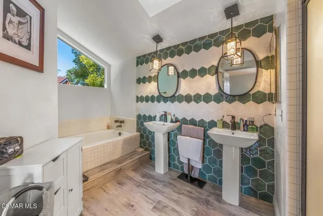 a bathroom with a sink mirror and bathtub