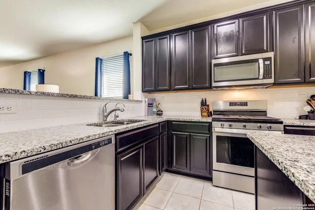 a kitchen with granite countertop stainless steel appliances and cabinets