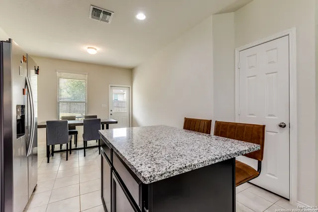 a dining hall with stainless steel appliances granite countertop a granite counter tops and white cabinets