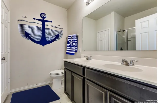 a bathroom with a sink a toilet and a mirror