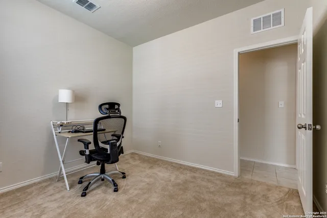 a view of a workspace with furniture and a window