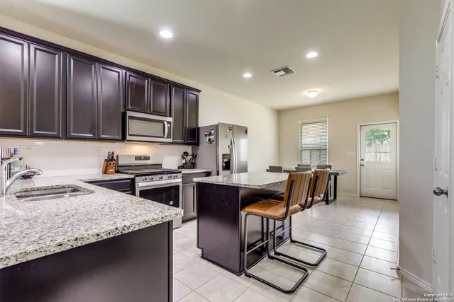a kitchen with granite countertop cabinets stainless steel appliances a sink and a window