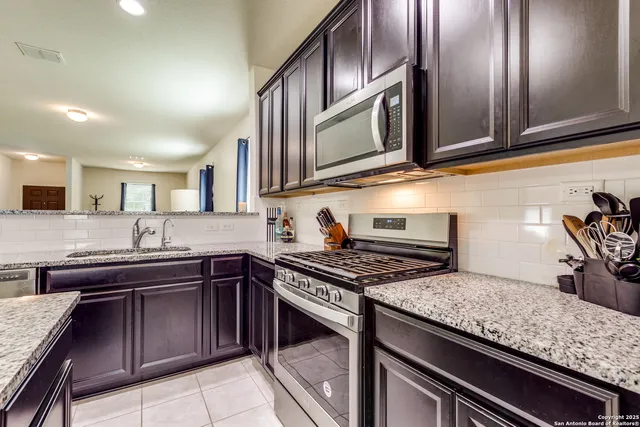 a kitchen with stainless steel appliances granite countertop a sink and cabinets