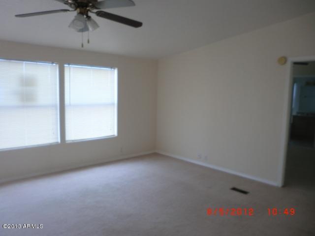 284 North Tomahawk Road Apache Junction, AZ 85119 - Photo 7 of 30 an empty room with a ceiling fan and window