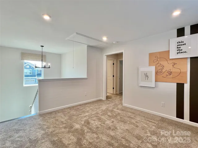 a view of an empty room and kitchen view