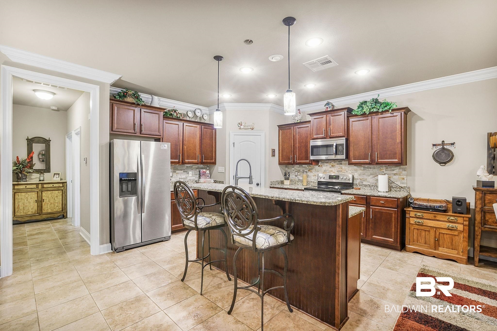 1090 Destin Avenue Foley, AL 36535 - Photo 7 of 30 Kitchen featuring appliances with stainless steel finishes, ornamental molding, decorative backsplash, light tile patterned floors, and light stone countertops
