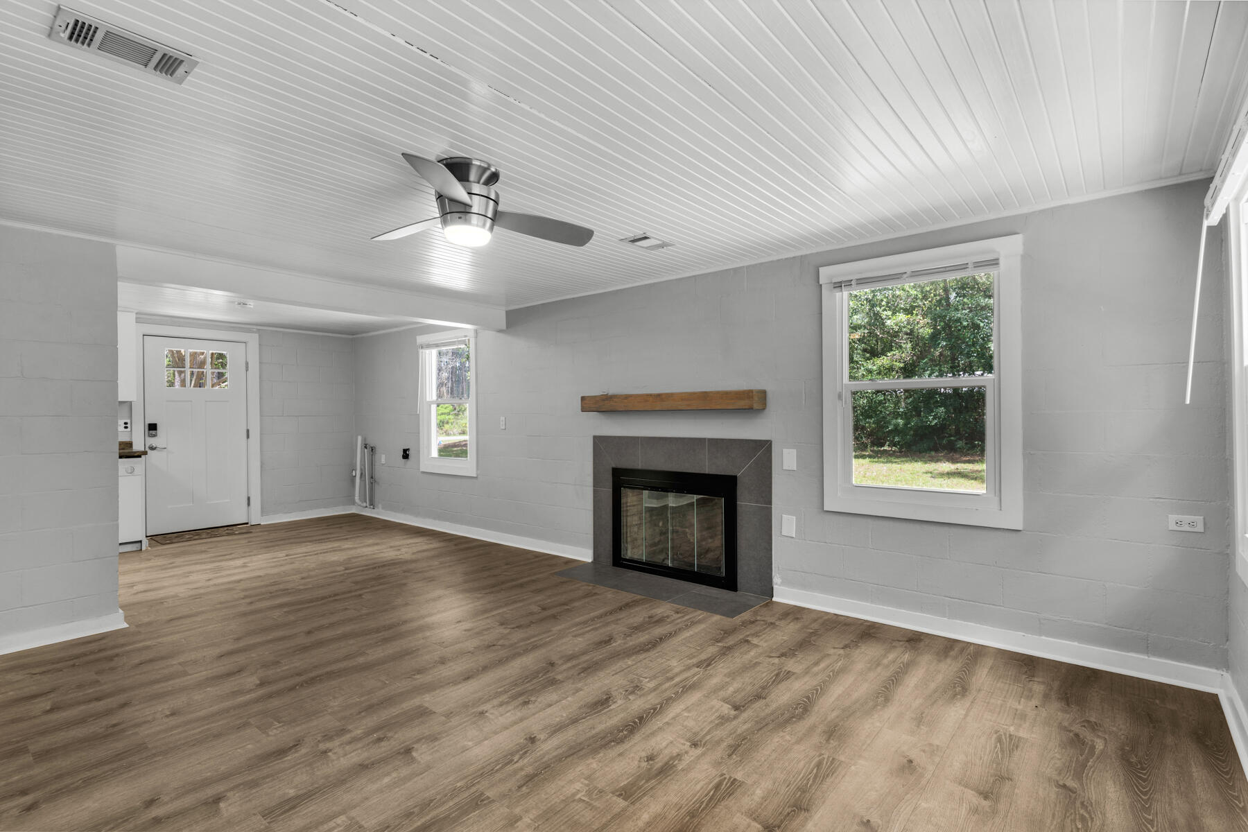 771 Alaqua Drive Freeport, FL 32439 - Photo 11 of 23 an empty room with wooden floor fireplace and windows