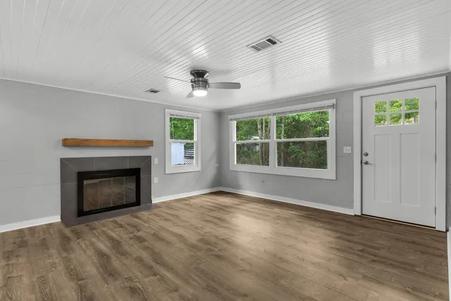 wooden floor fireplace and windows in an empty room