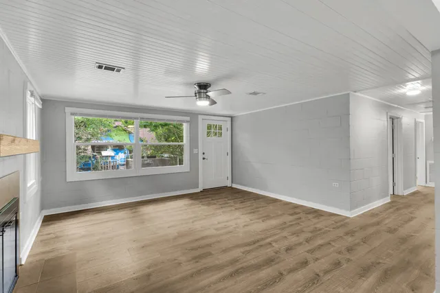 an empty room with windows and fireplace