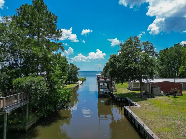 a view of swimming pool with seating space and trees in the background
