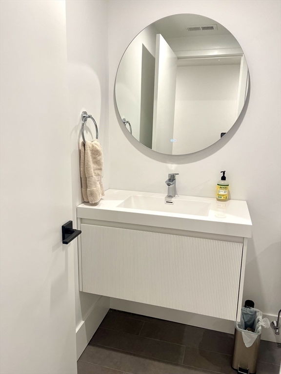 61 Allison Street, Unit 2 Newton, MA 02458 - Photo 24 of 26 a bathroom with a sink mirror and vanity