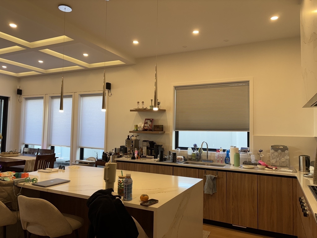 61 Allison Street, Unit 2 Newton, MA 02458 - Photo 7 of 26 a kitchen with kitchen island granite countertop a sink and cabinets