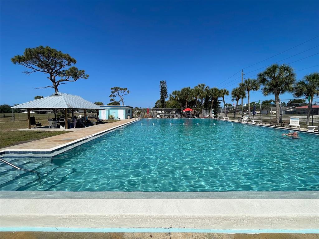1350 Lakeside Drive Venice, FL 34293 - Photo 60 of 64 a view of a yard with a table and chairs under an umbrella